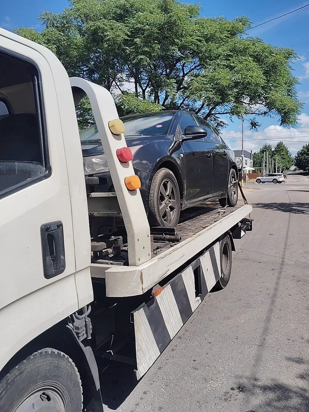Traslado de un sedán negro en una calle residencial